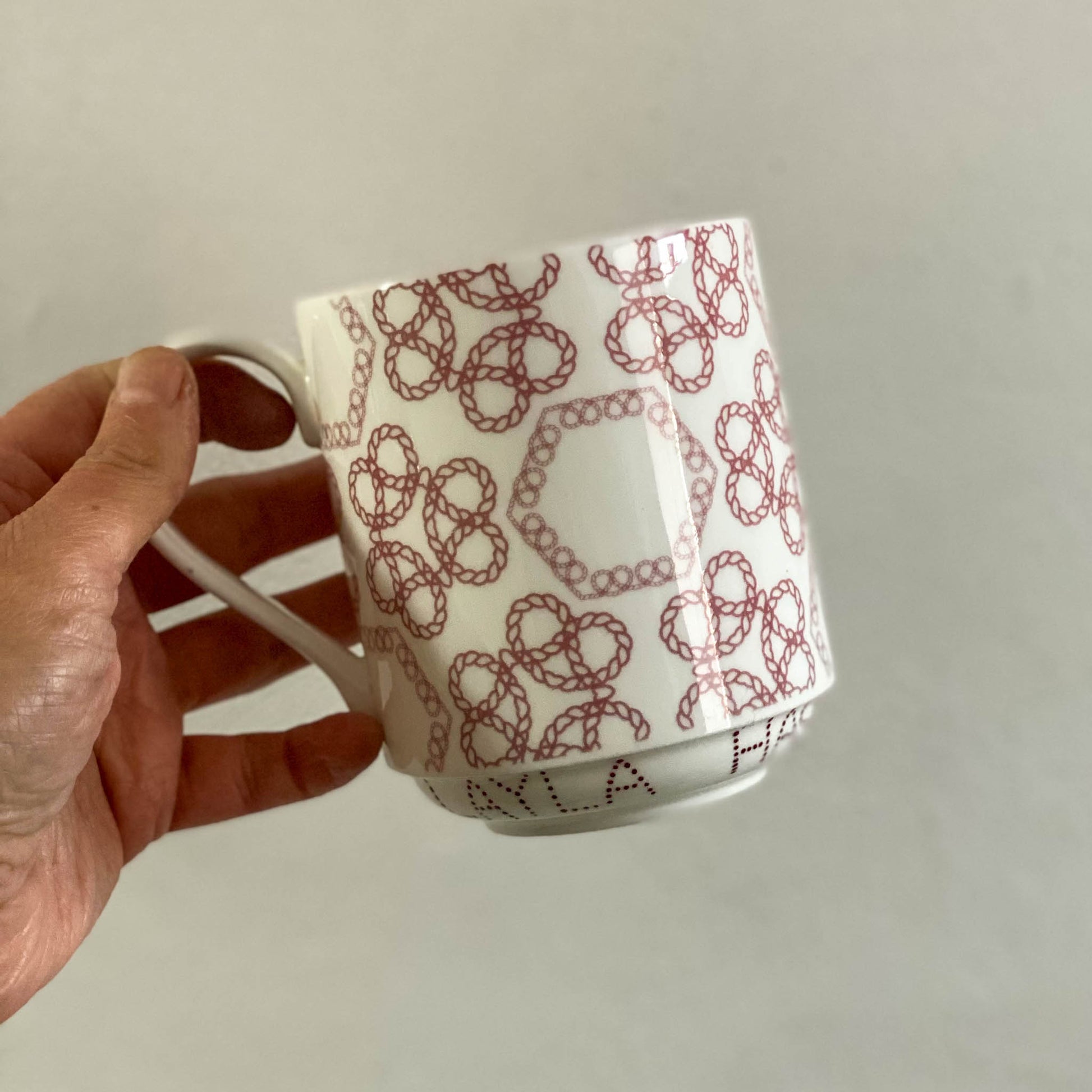 Bone china stacking mug with red Staffordshire knot pattern. Personalised for Box O Fun founder, Layla Hashim with handpainted lettering.