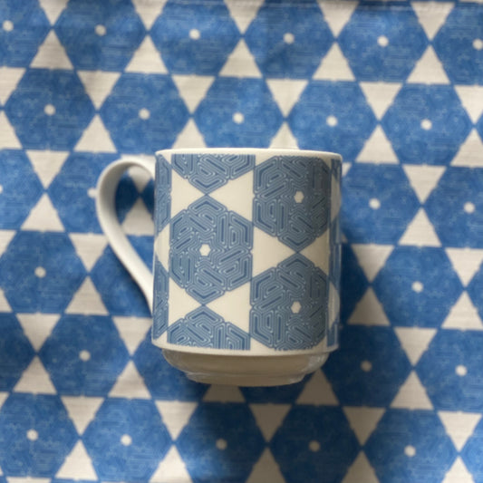 Blue geometric cup on top of matching tea towel.